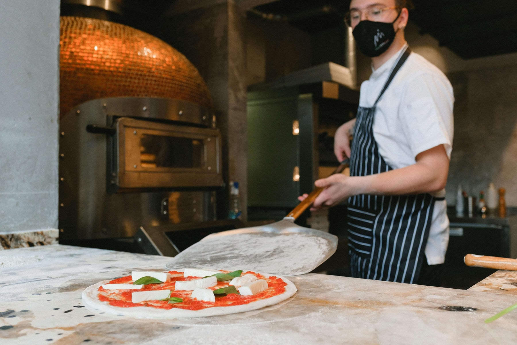 Person cooking with metal pizza peel