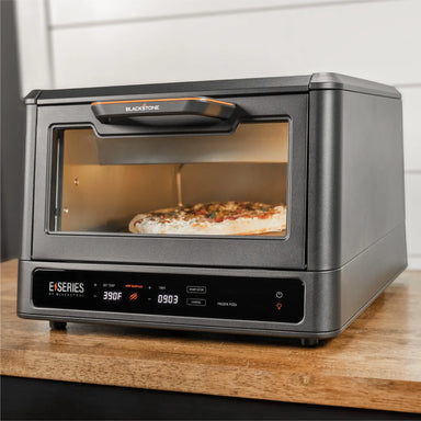 Blackstone E Series Electric Pizza Oven and Air Fryer cooking pizza on countertop