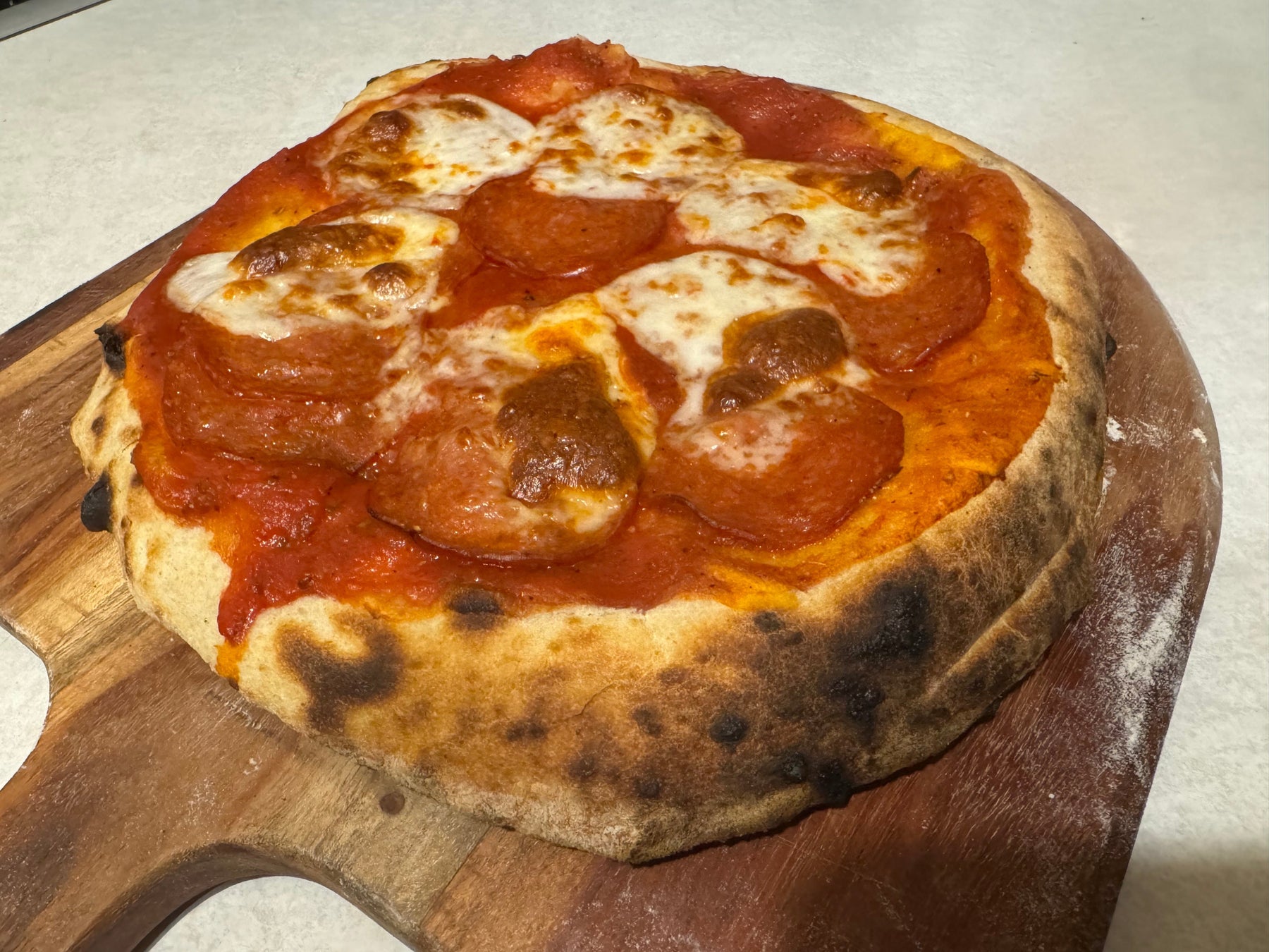 Budget pizza recipe: cooked pizza on pizza peel