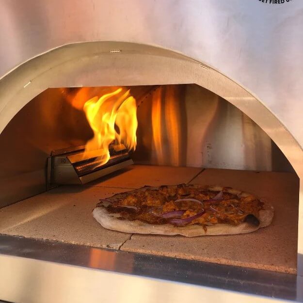 Pizza cooking in gas fired pizza oven